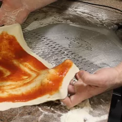 Pizzaschaufel mit Löchern, mit pizza zum Einlegen bereit